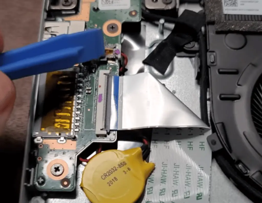 Removing the CMOS battery connector from the motherboard.